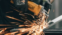 a man using a grinder on a piece of metal