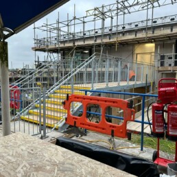 Elevated galvanized steel link bridge with access stairs and security gates