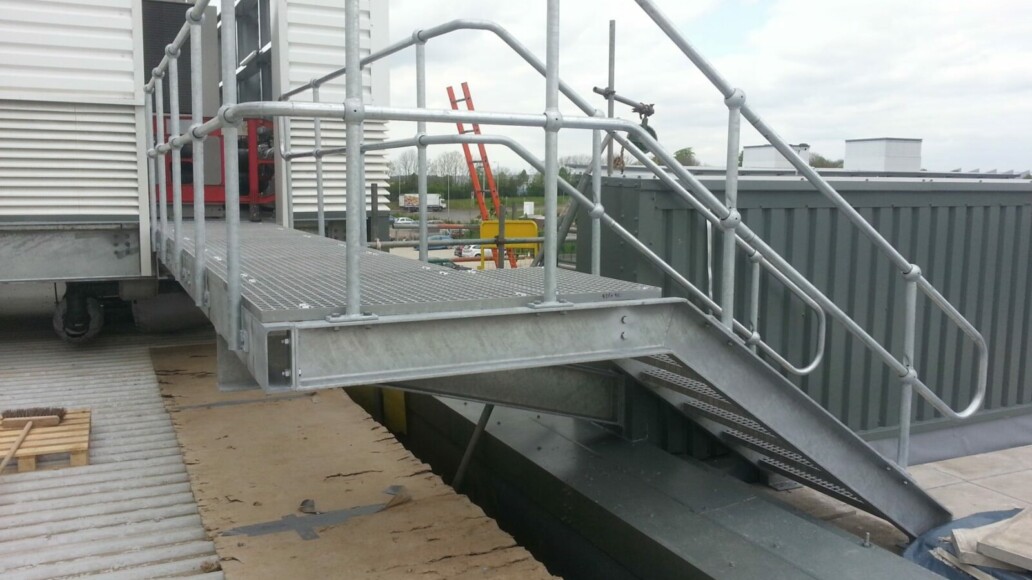 Galvanized rooftop plant access step-over above HVAC and utility services