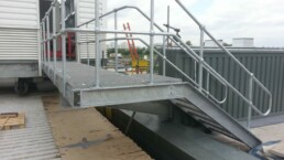Galvanized rooftop plant access step-over above HVAC and utility services