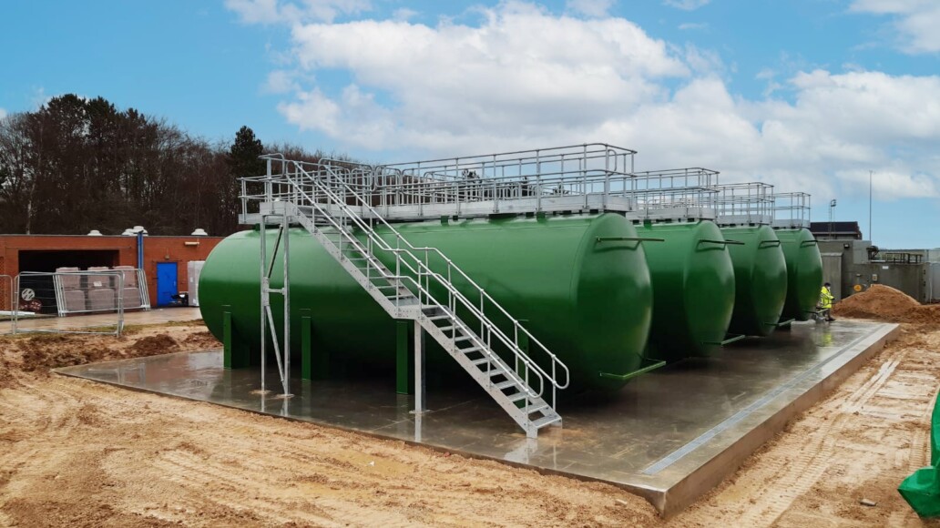 Galvanized access walkway and stairs connecting horizontal industrial storage tanks