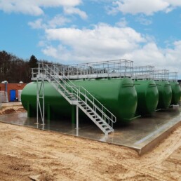 Galvanized access walkway and stairs connecting horizontal industrial storage tanks