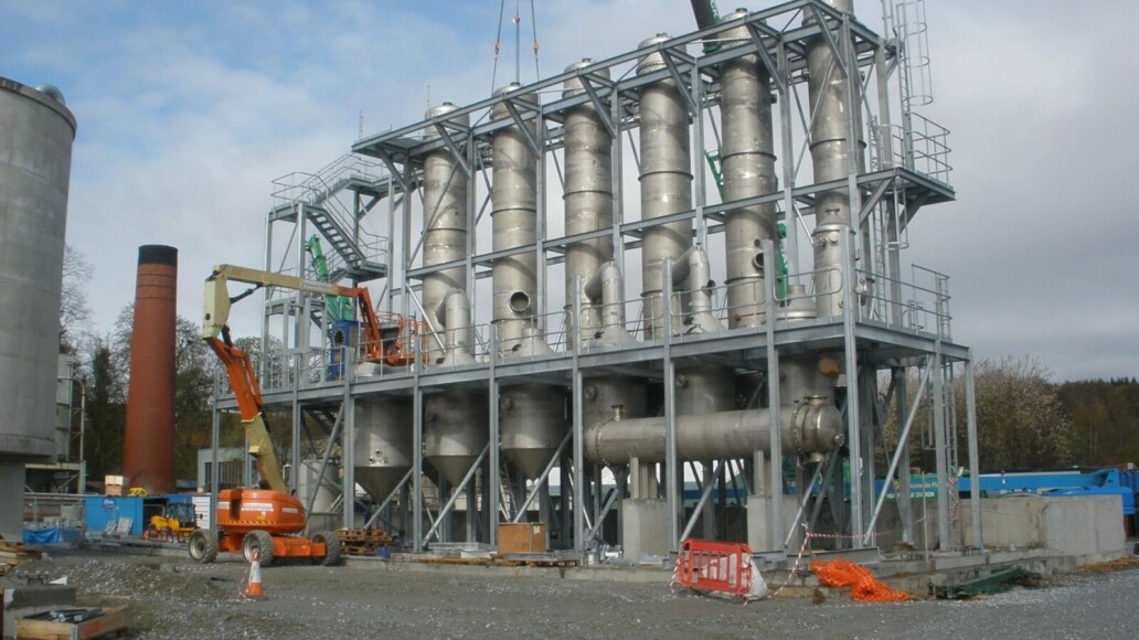 Multi-tier steel access gantry surrounding industrial process plant and pipework